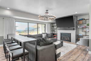 Living room with an inviting chandelier, light hardwood / wood-style flooring, and a fireplace