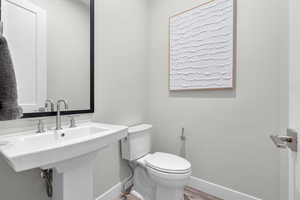 Bathroom with hardwood / wood-style flooring and toilet