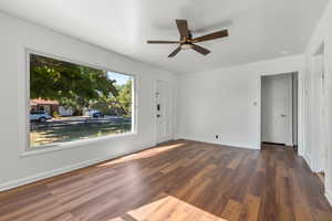 Living Roomfeaturing ceiling fan and dark wood-type flooring and large window