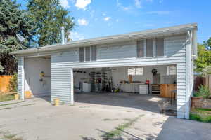 View of massive 4 car garage with doors open