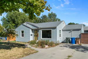 View of front of home, driveway, and gate to back yard and garage