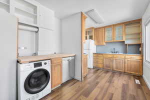 Laundry room with washer / clothes dryer, dark wood-type flooring, and kitchen sink