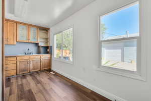 Kitchen featuring wood-type flooring and sink. View to back yard and garage.