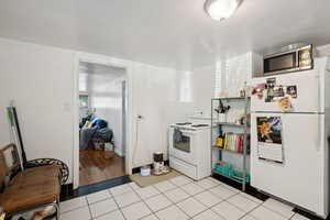 Kitchen with white appliances and light hardwood / wood-style floors