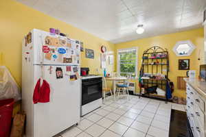 Kitchen featuring white cabinets, white appliances, and light tile patterned floors