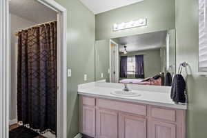 Bathroom with a textured ceiling and vanity