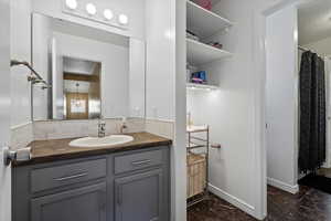 Bathroom featuring a textured ceiling, backsplash, and vanity