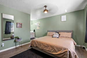 Bedroom featuring ceiling fan, dark hardwood / wood-style floors, and a textured ceiling