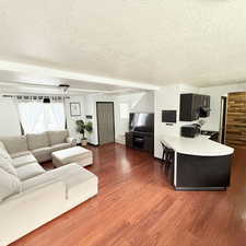 Living room with hardwood / wood-style floors and a textured ceiling