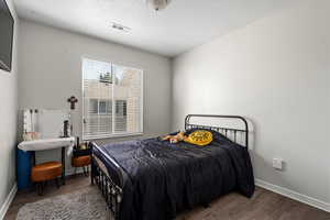 Bedroom with a textured ceiling and hardwood / wood-style flooring