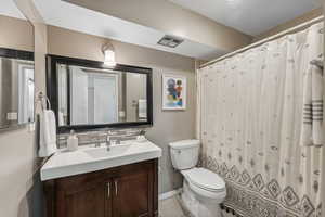 Bathroom featuring tasteful backsplash, a shower/tub with shower curtain, tile floors and contemporary vanity.