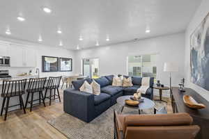 Living room with light hardwood / wood-style flooring and sink *Photo is of an existing home of the same layout. Colors for listed home could vary*