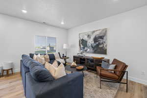 Living room with light hardwood / wood-style flooring *Photo is of an existing home of the same layout. Colors for listed home could vary*