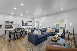 Living room featuring light wood-type flooring and sink *Photo is of an existing home of the same layout. Colors for listed home could vary*