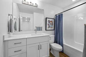 Full bathroom with vanity, hardwood / wood-style floors, toilet, and shower / bath combo *Photo is of an existing home of the same layout. Colors for listed home could vary*