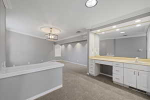 Bathroom with ornamental molding and vanity