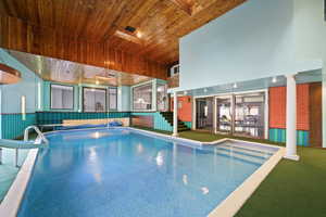 View of pool with a hot tub and decorative columns