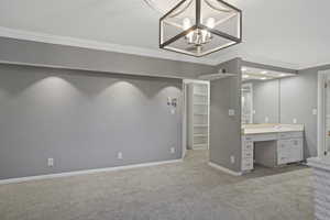 Interior space featuring vanity, a notable chandelier, and crown molding