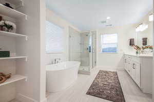 Bathroom featuring independent shower and bath and vanity