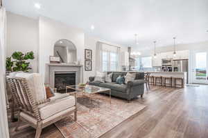 Living room featuring an inviting chandelier, a wealth of natural light, and light hardwood / wood-style floors