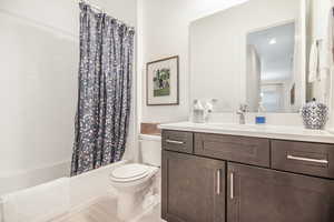 Full bathroom with hardwood / wood-style flooring, vanity, toilet, and shower / bath combination with curtain