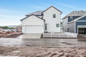 Back of house with a garage and a mountain view