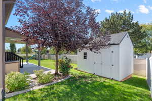 View of yard featuring a playground, a storage unit, and a patio area