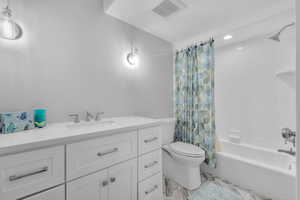 Full bathroom with shower / bath combo, vanity, and toilet