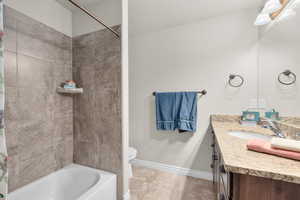 Full bathroom featuring shower / bathtub combination with curtain, tile patterned flooring, vanity, and toilet