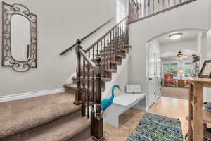 Stairway featuring ceiling fan and carpet floors