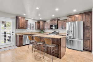 Kitchen featuring stainless steel appliances, plenty of natural light, a kitchen breakfast bar, and a kitchen island