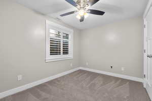 Carpeted empty room featuring ceiling fan