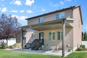 Back of house with a lawn and a patio area