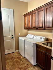 Washroom featuring independent washer and dryer and cabinets