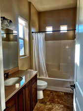 Full bathroom with shower / tub combo with curtain, vanity, and toilet