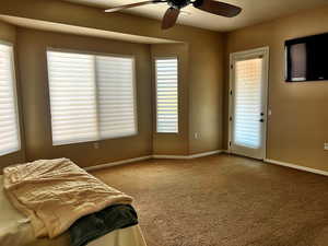 Carpeted bedroom featuring access to outside and ceiling fan