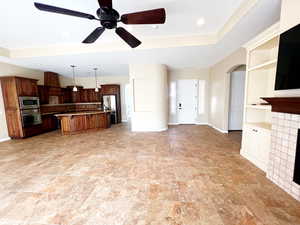 Open Floor Plan room featuring ceiling fan and a tiled fireplace