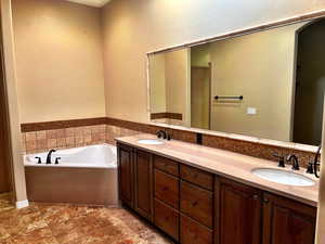 Bathroom featuring backsplash, vanity, and a separate tub/shower