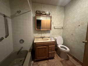 Full bathroom featuring tiled shower / bath combo, vanity, and toilet