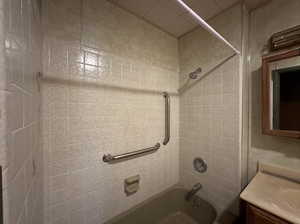 Bathroom with tiled shower / bath and vanity