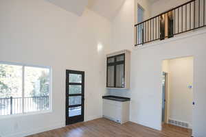 Entryway with hardwood / wood-style flooring and high vaulted ceiling