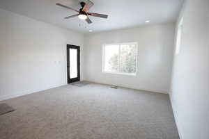 Carpeted spare room featuring ceiling fan