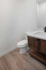 Bathroom featuring vanity, toilet, and wood-type flooring