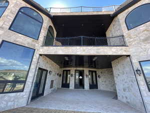 Back of property with a balcony and a patio area