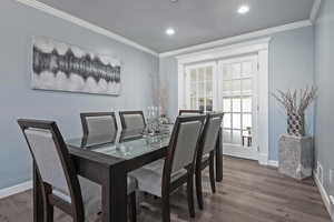 Dining space with ornamental molding and hardwood / wood-style floors