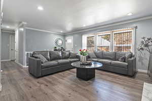 Living room with crown molding and dark hardwood / wood-style flooring