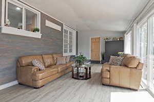 Living room with wood-type flooring, vaulted ceiling, and plenty of natural light