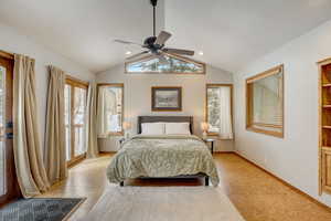 Bedroom featuring ceiling fan, lofted ceiling, access to exterior, and multiple windows