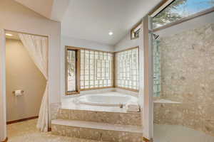 Bathroom featuring lofted ceiling and independent shower and bath