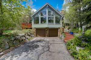 View of property exterior featuring a garage and a deck